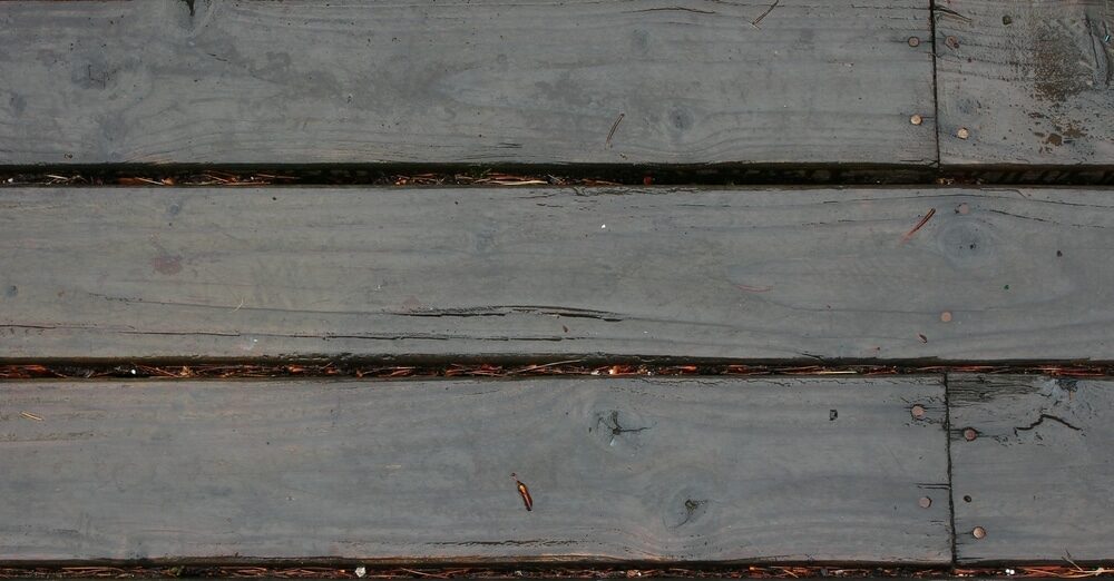 Weathered grey wooden decking with visible signs of aging and patina.