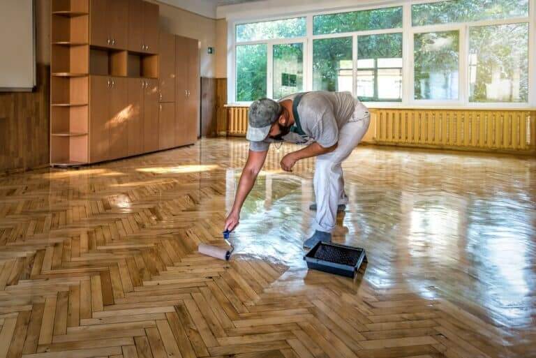Lacquering,Parquet,Floors.,Worker,Uses,A,Roller,To,Coating,Floors.