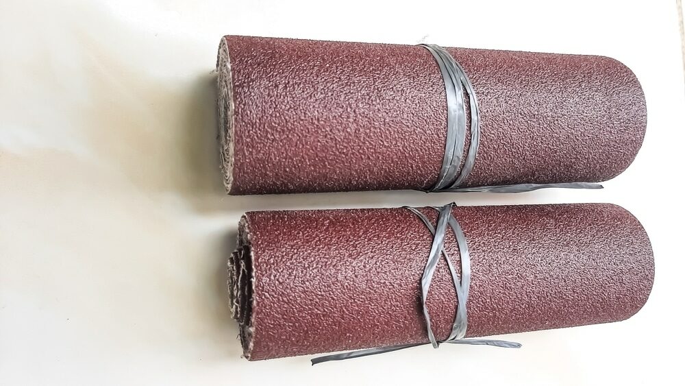 Two rolls of sandpaper secured with wire on a white background.