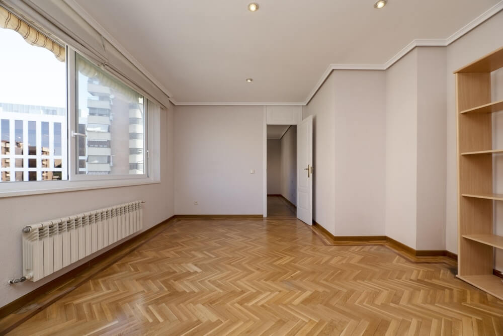 A bright and spacious room in Biggin Hill, UK, featuring beautifully refinished herringbone parquet flooring by Mr Sander®. The light oak wood floors are restored to their original shine, highlighting the expertise of Mr Sander® in floor sanding and refinishing services.