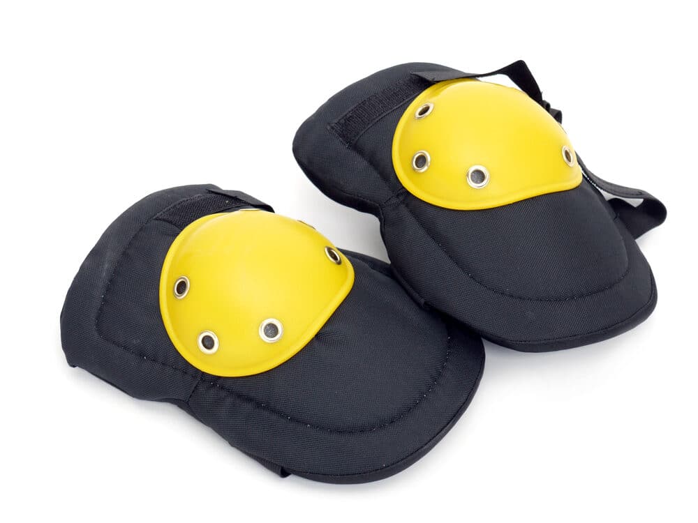 Pair of black and yellow knee pads isolated on a white background.