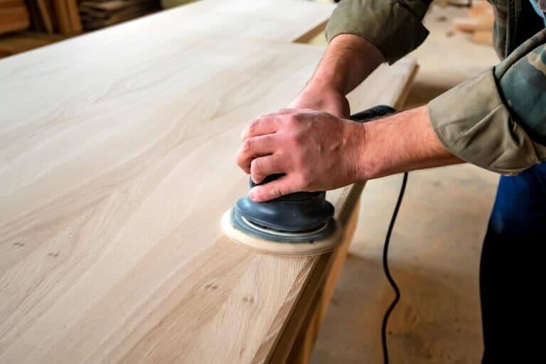Man,Sanding,Wood,With,Orbital,Sander,In,A,Workshop