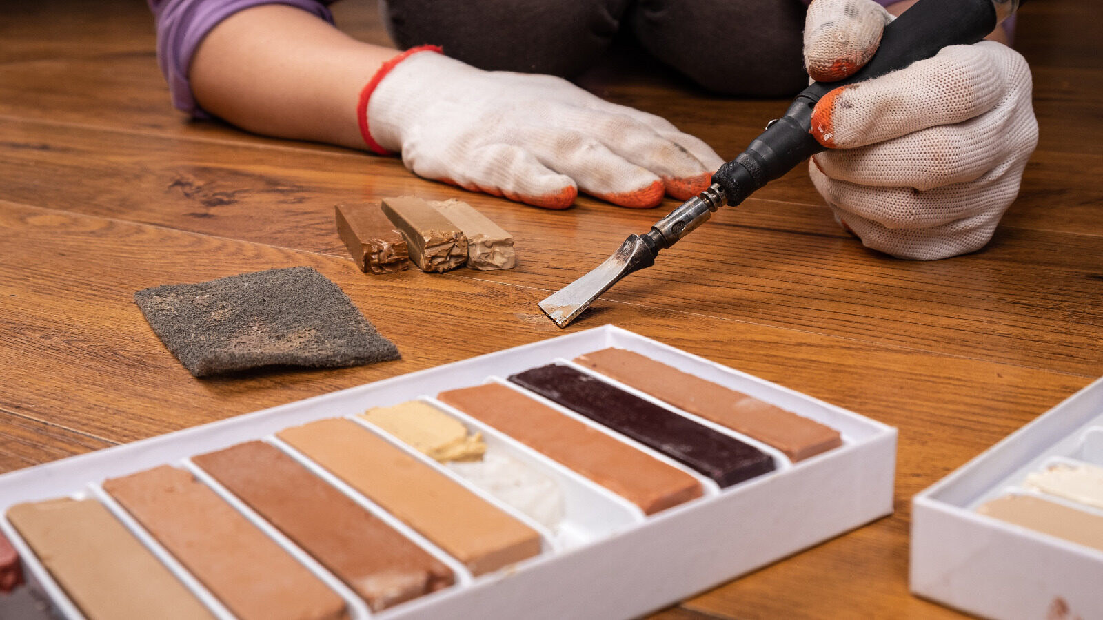 Spot Repair on oak hardwood plank floor using hot knife and colour-matched hard-wax filler to fix scratches and small gouges