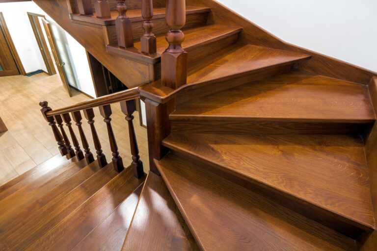 Stair Tread Sanding results on an oak hardwood winder staircase, showing smooth, glossy wooden treads and matching oak hardwood flooring in the hallway.