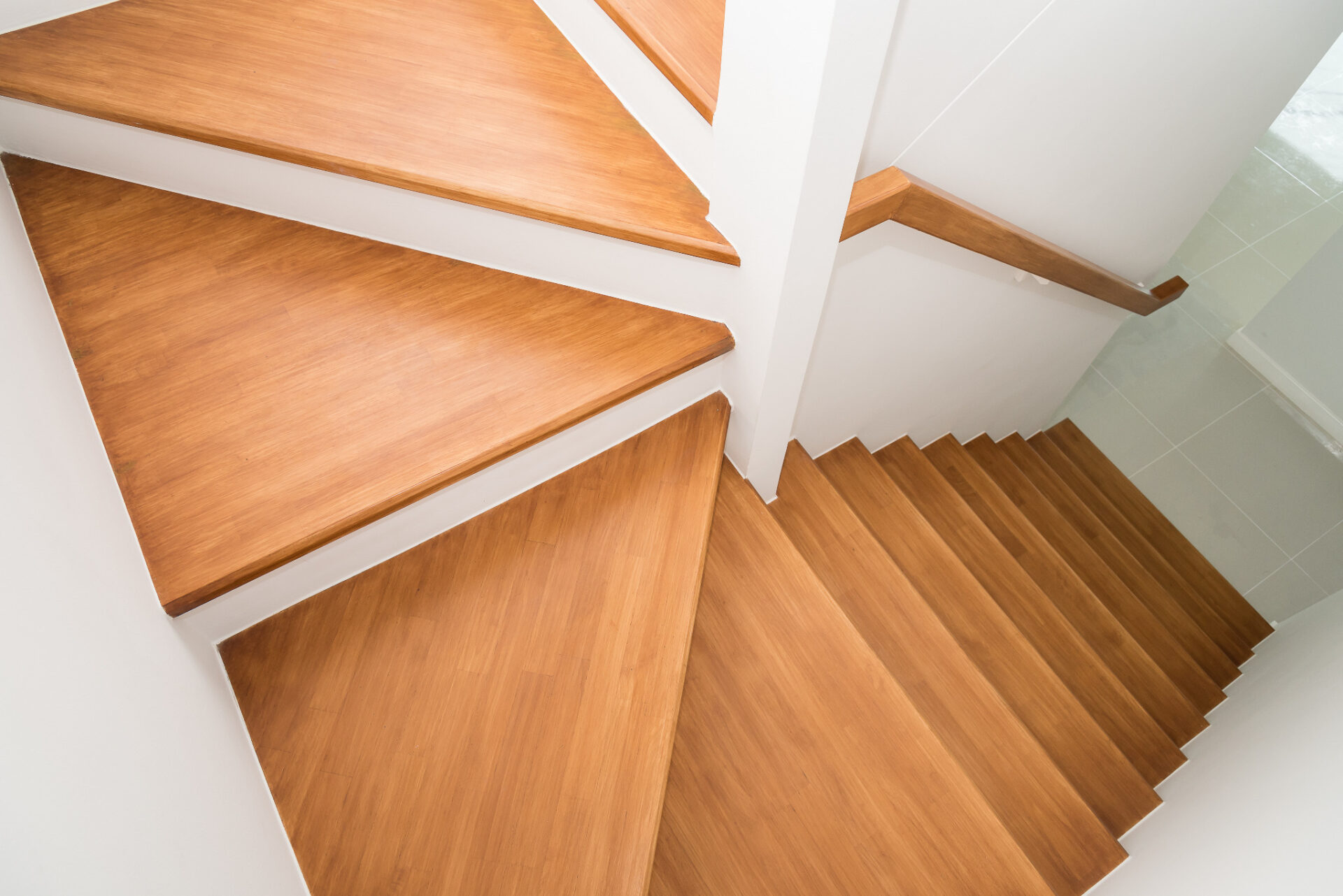Freshly restored timber staircase with smooth treads and clean white walls after professional Staircase Sanding in London on solid oak wood steps.
