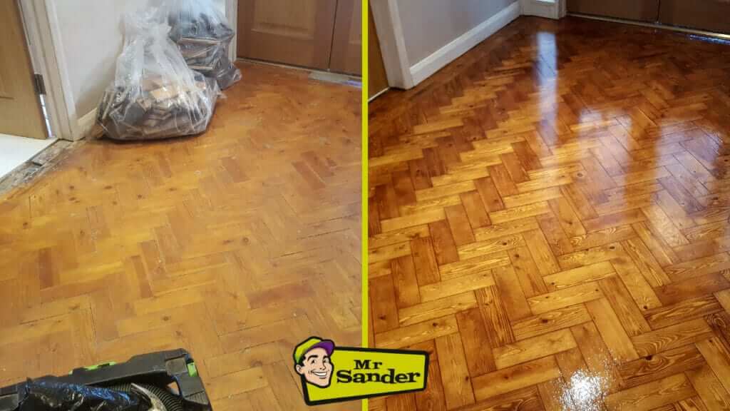 A before-and-after image showing a herringbone parquet wooden floor. The left side depicts the floor before restoration, appearing dull and worn with some debris and equipment in the area. The right side showcases the floor after restoration, with a rich, polished, and shiny finish. The transformation highlights the improved color and sheen of the wooden flooring.