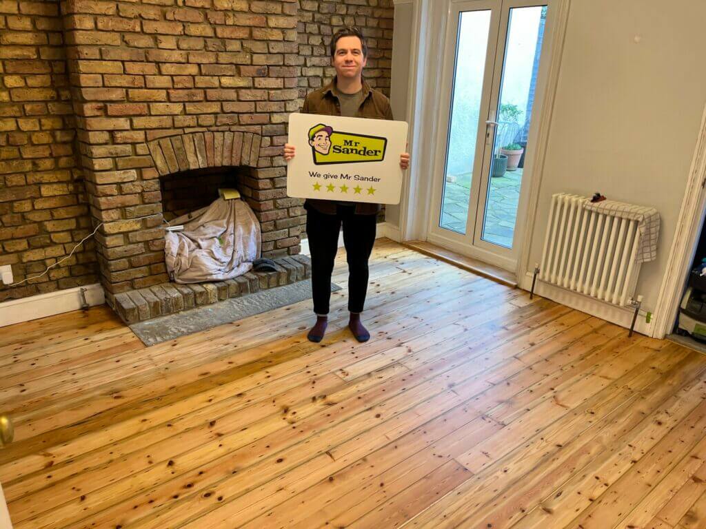 Happy Client holding a sign of Mr Sander