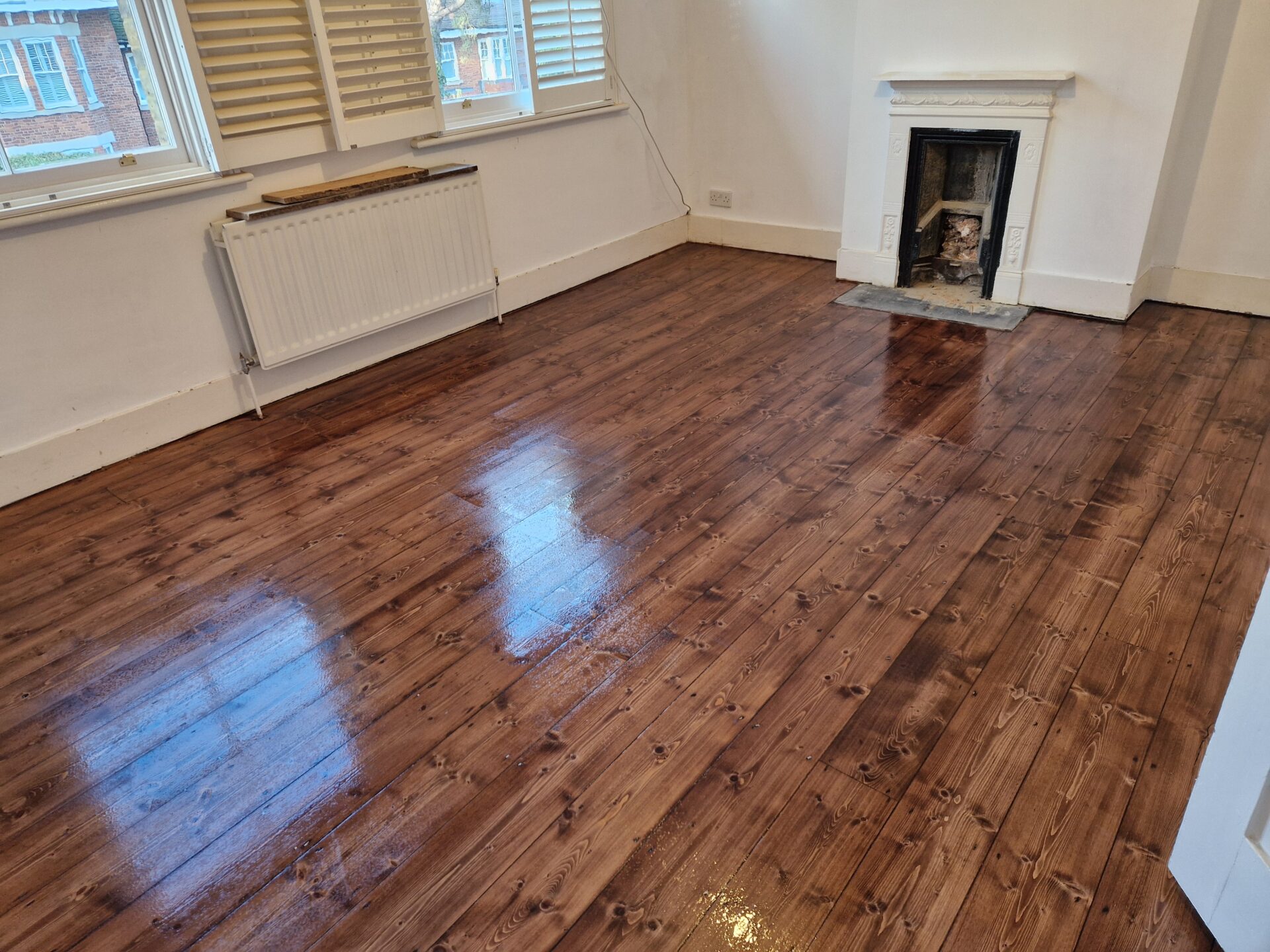 Victorian Pine Floor Sanding on solid pine floorboards, finished medium-brown with a high-gloss seal highlighting knots and grain.