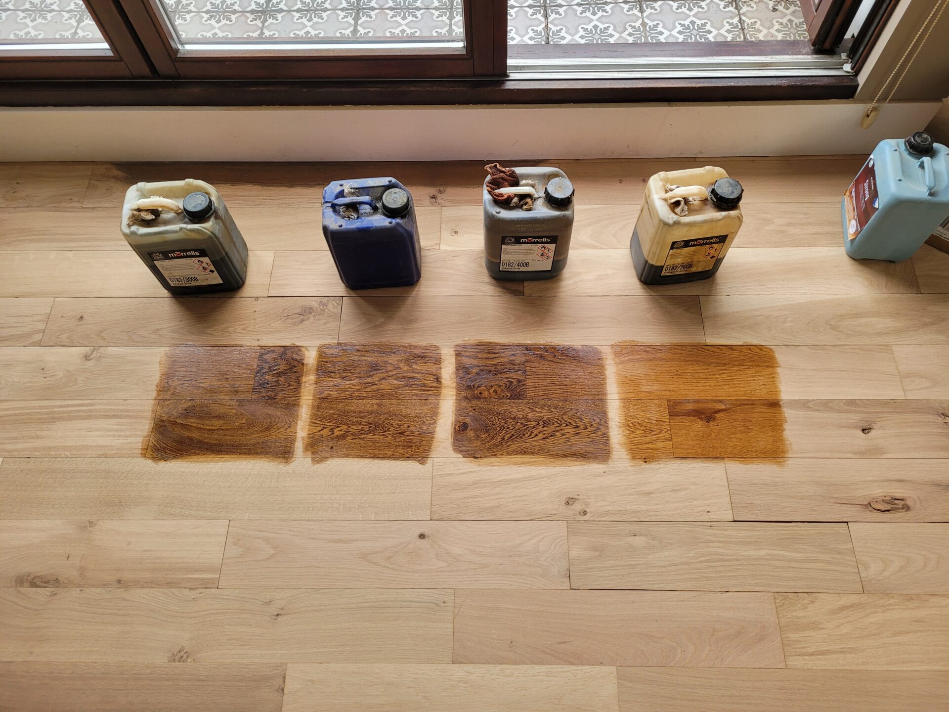 Selection of stain samples tested on oak plank hardwood during a Wood Floor Fitting project.