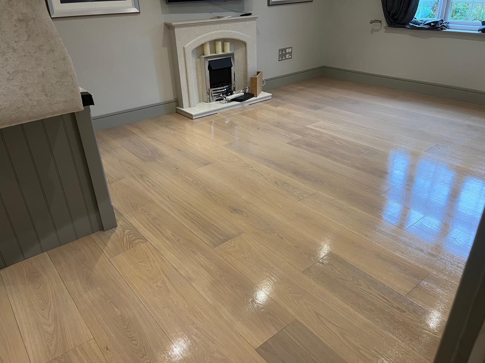 Wood Floor Sanding on an engineered oak hardwood plank living room floor, restored to a smooth, glossy finish around a modern fireplace.