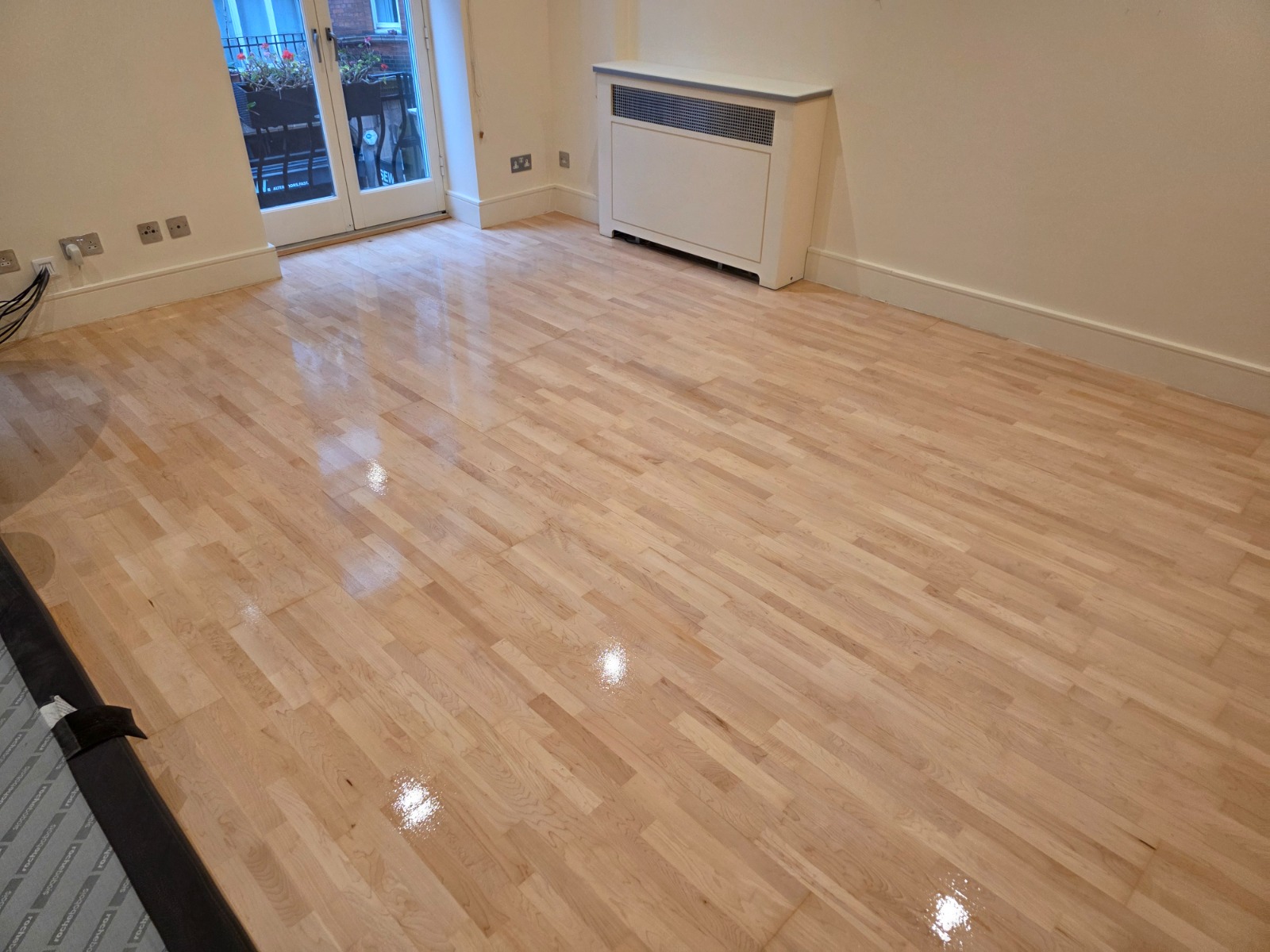 Wood Floor Sanding on a light maple hardwood block parquet floor, freshly refinished to a smooth, glossy finish in a modern living room.