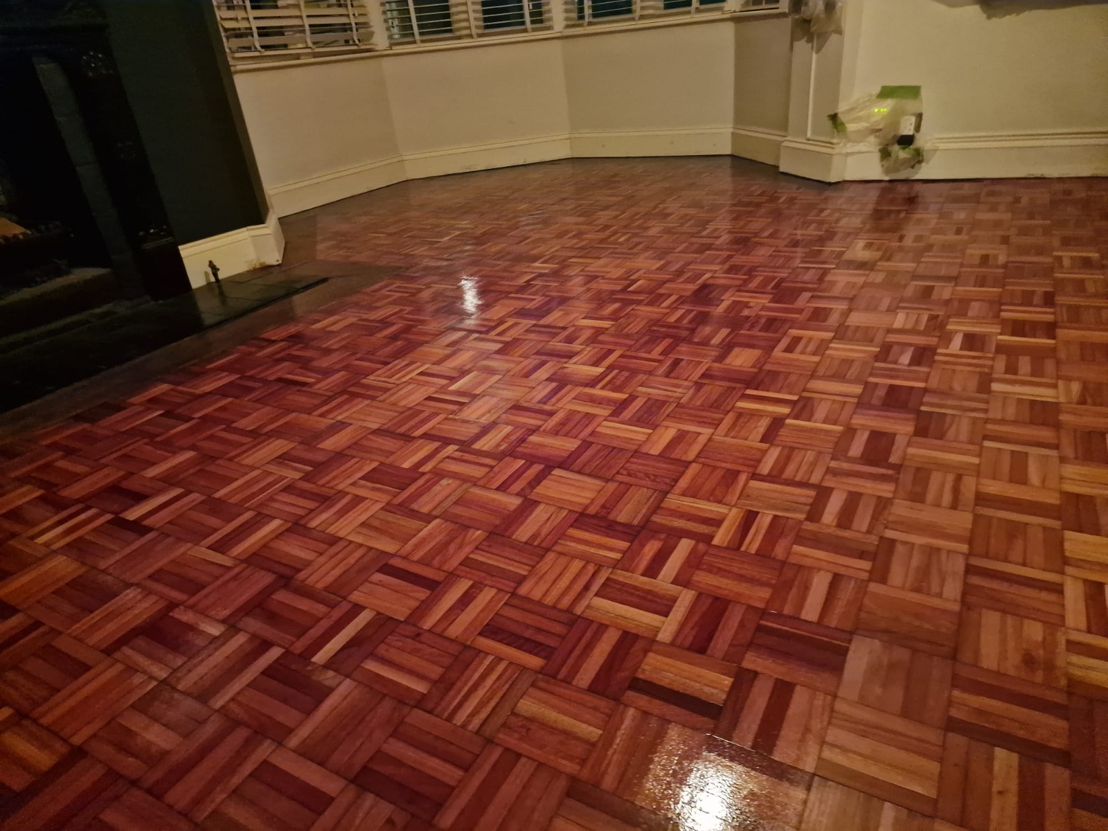 Geniş bir oturma odasında zengin, parlak meşe mozaik kaplamayı gösteren, Ahşap Zemin Zımparalama sonrasında yeni restore edilmiş parke ahşap zemin.