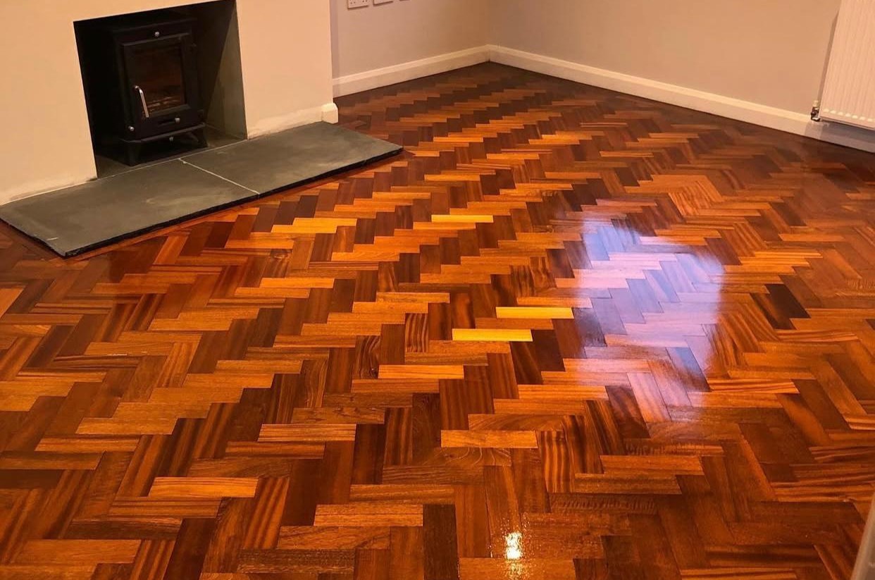 A fully restored and glossy oak herringbone parquet floor after professional wood floor sealing.